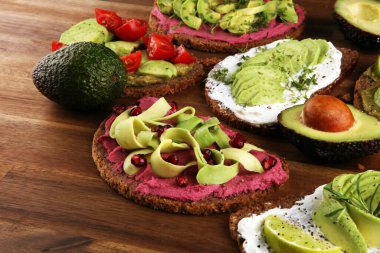 Avokado tostu. Avokado ve domates ve pancar gibi malzemelerle sağlıklı çavdarlı sandviç çeşitleri.