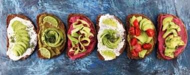 Avokado tostu. Avokado ve domates ve pancar gibi malzemelerle sağlıklı çavdarlı sandviç çeşitleri.