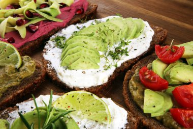 Avokado tostu. Avokado ve domates ve pancar gibi malzemelerle sağlıklı çavdarlı sandviç çeşitleri.