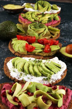 Avokado tostu. Avokado ve domates ve pancar gibi malzemelerle sağlıklı çavdarlı sandviç çeşitleri.