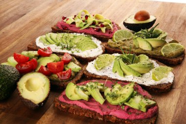 Avokado tostu. Avokado ve domates ve pancar gibi malzemelerle sağlıklı çavdarlı sandviç çeşitleri.