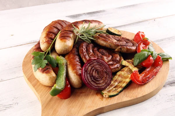 グリルソーセージや野菜とバーベキューに野菜とおいしいグリル肉を盛り合わせ 食品の背景とソーセージ — ストック写真
