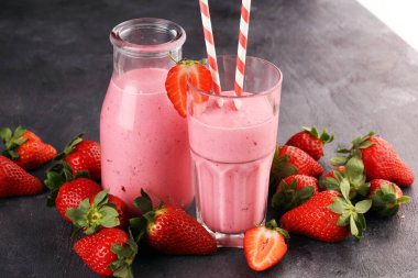 Bir bardak taze çilekli süt, smoothie veya milkshake ve taze çilek. Sulu meyveli sağlıklı yiyecek ve içecek konsepti 