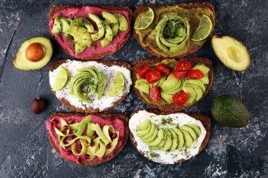 Avokado tostu. Avokado ve domates ve pancar gibi malzemelerle sağlıklı çavdarlı sandviç çeşitleri.
