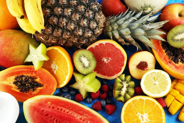 Tropical fruits background, many colorful ripe tropical fruits on rustic table