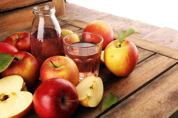 Apple cider drink and apples with leaves on rustic table