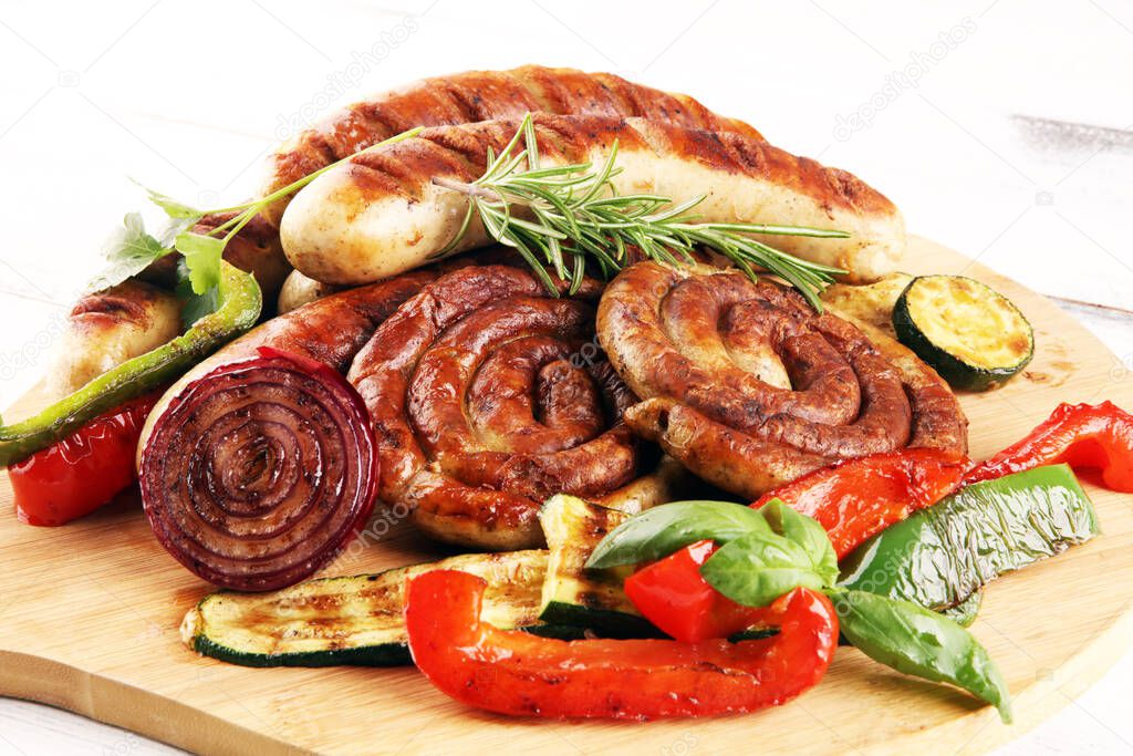Assorted delicious grilled meat with vegetable on a barbecue with grilled sausages and vegetables. Food background and sausages