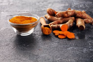 Zerdeçal tozu ve kırsal arka planda taze zerdeçal. Taze organik baharat.