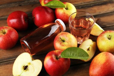 Elma şarabı ve kırsal masada yaprakları olan elmalar.