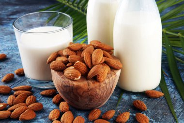Arka planda taze fındıklı badem sütü ve palmiye yaprakları. Badem vejetaryen süt ürünleri