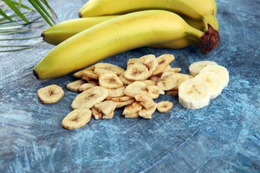 Ev yapımı kurutulmuş muz cipsi ve taze muz ve dilimler.