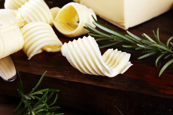 Bloque Amarillo Mantequilla Fresca Rodajas Sobre Tabla Cortar Madera Remolinos — Foto de Stock