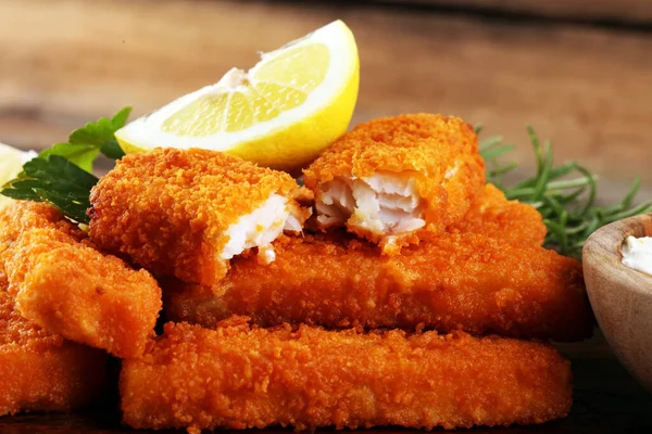 fresh fish fingers with remoulade sauce. breaded fish fingers with lemon