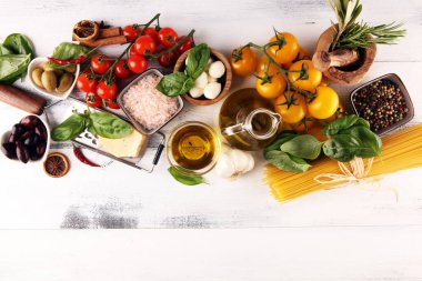 İtalyan yemek arkaplanı, baharat, domates, fesleğen, spagetti, zeytin, parmesan, zeytinyağı, sarımsak, biber ve biberiye.