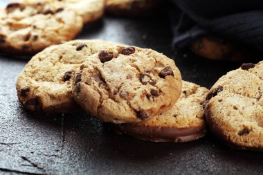 Tahta masada çikolatalı kurabiyeler. Çikolata parçacıklı kurabiyeler. Ahşap arka planda ev yapımı yemekler.