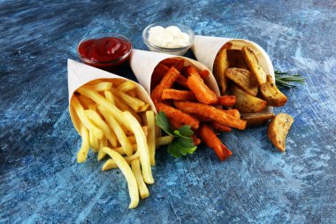 Patates kızartması çeşitleri. Patates kamışı, patates kızartması, arka planda öğle yemeği için tatlı patates.