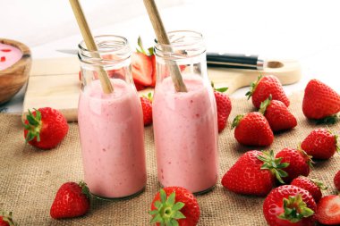 Bir bardak taze çilekli süt, smoothie veya milkshake ve taze çilek. Sulu meyveli sağlıklı yiyecek ve içecek konsepti 