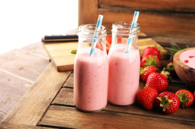 Bir bardak taze çilekli süt, smoothie veya milkshake ve taze çilek. Sulu meyveli sağlıklı yiyecek ve içecek konsepti 