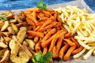 Patates kızartması çeşitleri. Patates kamışı, patates kızartması, arka planda öğle yemeği için tatlı patates.