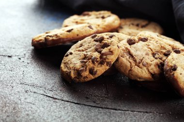 Tahta masada çikolatalı kurabiyeler. Çikolata parçacıklı kurabiyeler. Ahşap arka planda ev yapımı yemekler.