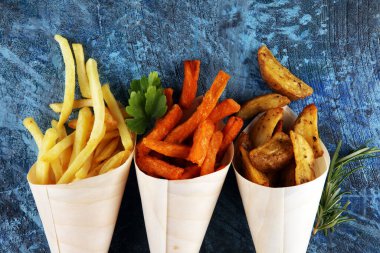 Patates kızartması çeşitleri. Patates kamışı, patates kızartması, arka planda öğle yemeği için tatlı patates.
