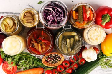 Sebzeleri cam kavanozlarda saklar. Salatalık turşusu, havuç, mayalanmış lahana ve soğan.