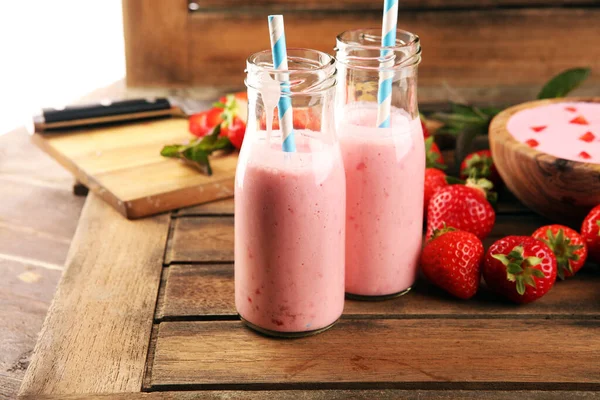 Bir bardak taze çilekli süt, smoothie veya milkshake ve taze çilek. Sulu meyveli sağlıklı yiyecek ve içecek konsepti 