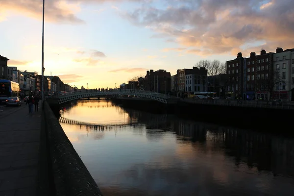 Dublin éjszakai jelenet Hapenny híd és Liffey folyó fényei. Írország — Stock Fotó