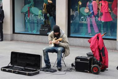 Dublin İrlanda, 20 Şubat 2018: Editör fotoğraf ipuçları yapmaya çalışmadan bir sokak sanatçı olarak bir gitar çalmak bir adam. Kayıt dışı ekonomi Dublin'de büyük