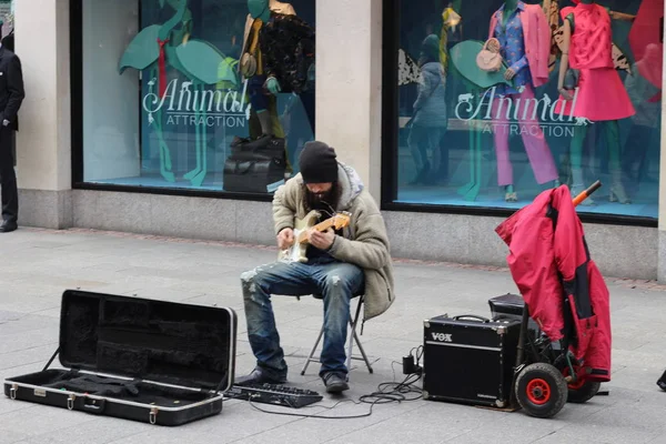 Dublin İrlanda, 20 Şubat 2018: Editör fotoğraf ipuçları yapmaya çalışmadan bir sokak sanatçı olarak bir gitar çalmak bir adam. Kayıt dışı ekonomi Dublin'de büyük