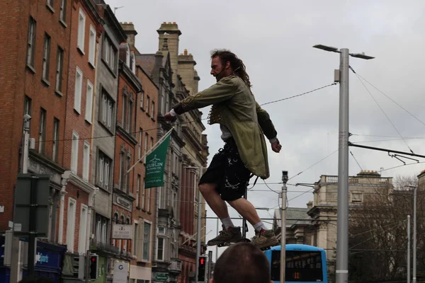 Un artista callejero está en un monociclo haciendo una actuación en la calle Grafton. La economía informal es un punto central de la industria turística de Dublín . — Foto de Stock