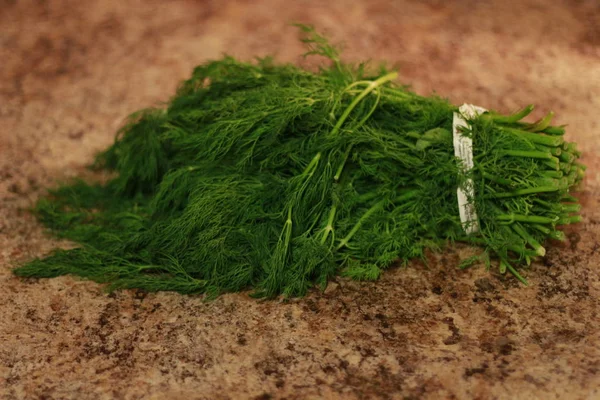 Bunch of fresh dill herbs and on granite table, top view, copy space. — Stock Photo, Image