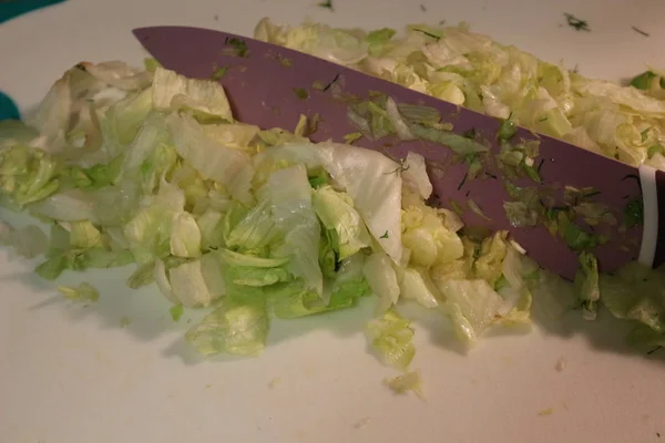 Eisbergsalat wird auf einem Schneidebrett zerkleinert — Stockfoto