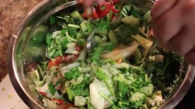 Chef malzemeler bir kase sebze salatası karışımları. Sebze salatası bir kapta karıştırarak, yakın çekim. Bir vejetaryen salata malzemeleri karıştırın. Sebze salatası hazırlanması. Yemek yemek