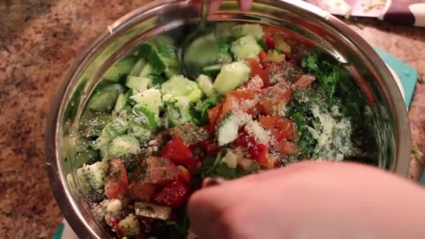 Lo chef mescola ingredienti d'insalata vegetale in una boccia. Primo piano di mescolare l'insalata vegetale in una ciotola. Mescolare gli ingredienti di un'insalata vegetariana. Preparazione di insalata vegetale. Cucinare il cibo — Video Stock