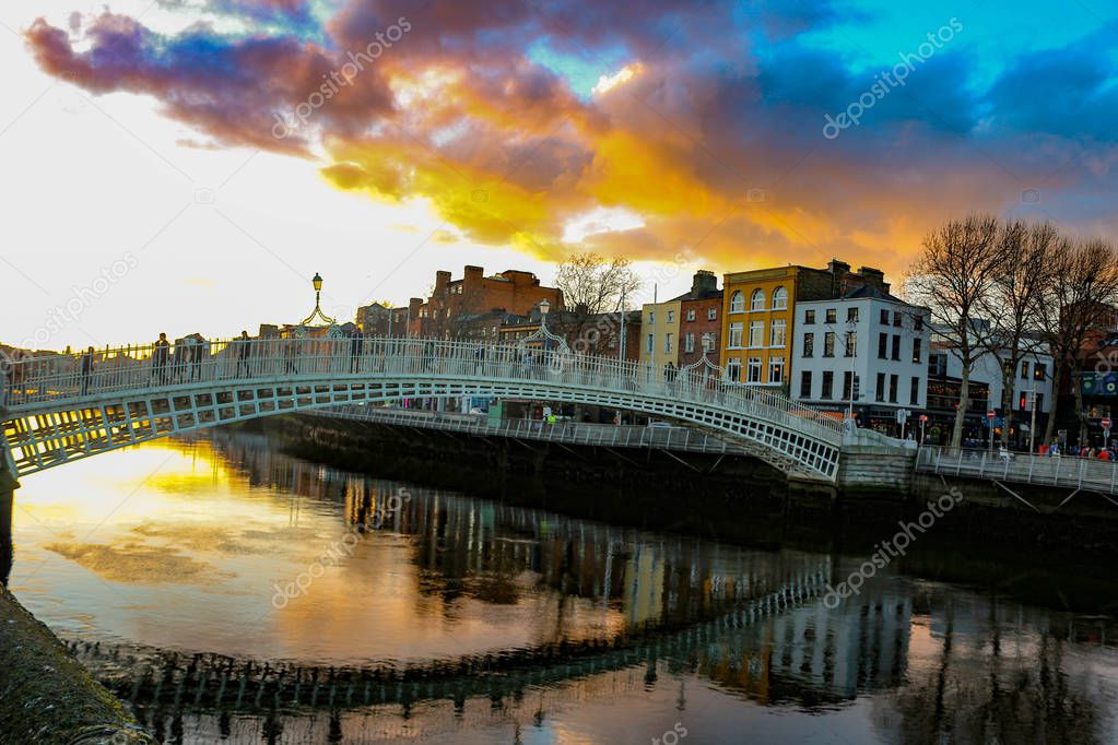 Dublin night scene with Ha'penny bridge and Liffey river lights . Ireland. A very popular spot to visit while you are in Dublin. this bridge formerly charged half a penny to cross hence the name.