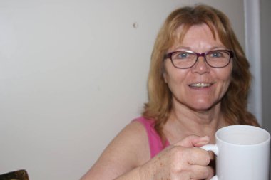 London Ontario Kanada - 23 Nisan 2018: Bir üst düzey kadın 60-kupa kahve tutarak ve rahatlatıcı bir an Kanada'da görüntüleme 65 Editör fotoğrafı.