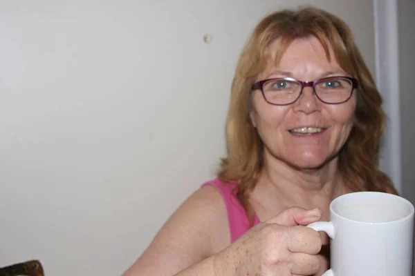 London Ontario Kanada - April 23 2018: Redaktionella fotografi av en äldre kvinnor 60-65 håller en kaffekopp och visar en avkopplande stund i Kanada. — Stockfoto