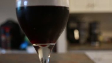 Kırmızı şarapla dolu bir mutfakta şarap kadehi.