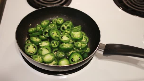 Fatias de ato de fritar de jalapenos em uma panela de ato de fritar — Vídeo de Stock