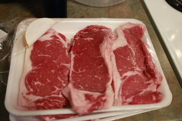 Rustik bir tarzda tuz ve biber ile ahşap arka plan üzerinde ahşap Tahta taze ham striploin biftek, üst görünümü. — Stok fotoğraf