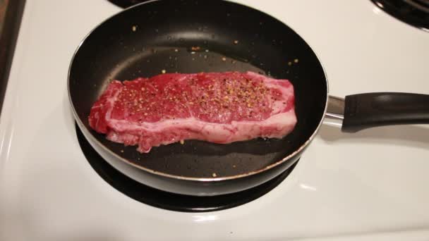 Freír dos trozos de filetes en la sartén en casa. Freír dos bistecs en una sartén en casa — Vídeos de Stock