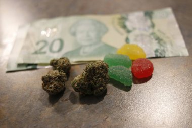Esrar yenilebilir, tıbbi marihuana, CBD aşılanmış sakızlar ve renkli jelibon ayıları ve karanlık arka planda fotokopi alanı olan ot tomurcukları ile yakın plan ile yenilebilir ot konsepti teması.