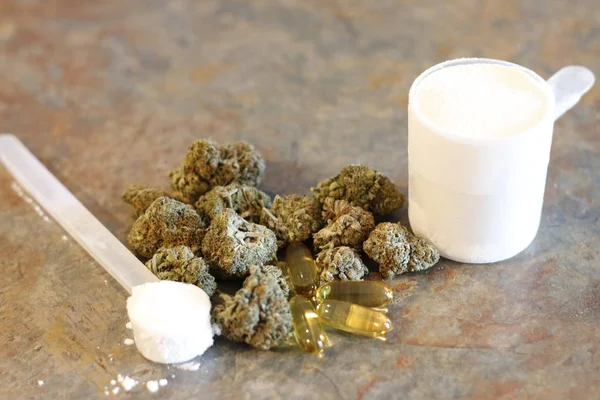 Knospen Marihuana neben einer Kugel Protein und Kreatin mit Fischöl-Pillen davor — Stockfoto