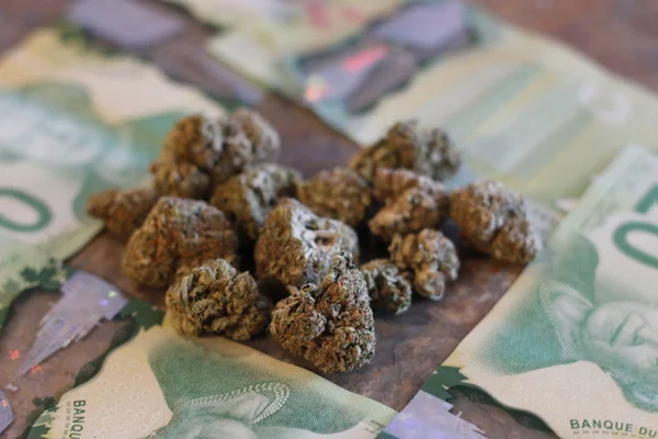 Dinheiro canadiano e maconha em um balcão de granito — Fotografia de Stock