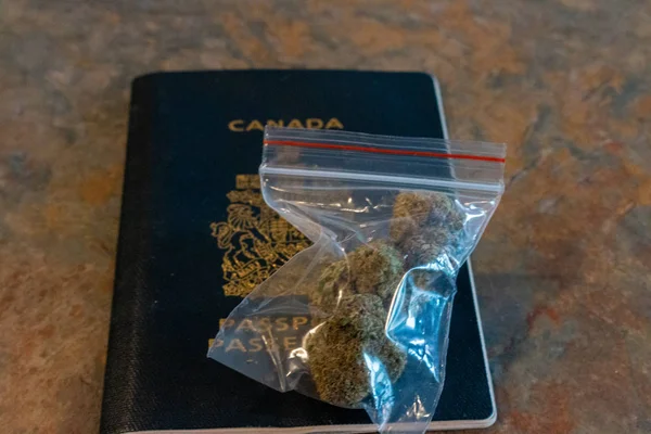 Σακούλα μαριχουάνα σε καναδικό διαβατήριο. θέμα της νόμιμης ψυχαγωγικής χρήσης κάνναβης. — Φωτογραφία Αρχείου