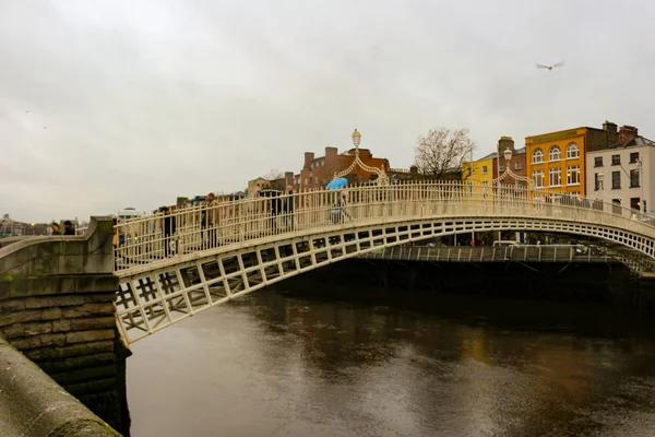Dublin Írország, 2018. február 18.: A hapenny híd szerkesztői fotója egy felhős napon. — Stock Fotó