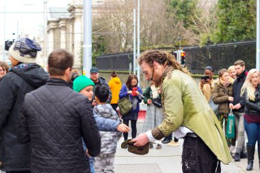 Dublin İrlanda, 19 Şubat 2018: Sokak performansından sonra para toplayan bir adamın editör fotoğrafı.