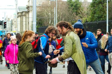 Dublin İrlanda, 19 Şubat 2018: Sokak performansından sonra para toplayan bir adamın editör fotoğrafı.