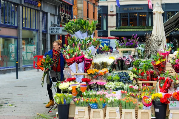 Dublín Irlanda, febrero18 2018: Foto editorial de una mujer vendiendo flores al costado de la carretera en Irlanda . — Foto de Stock
